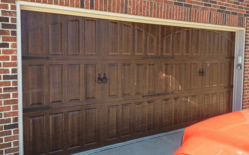carriage style residential garage door with decorative hardware