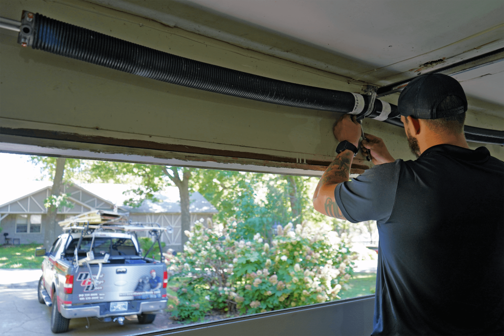 Discount Garage Door technician replacing torsion spring on residential garage door in Tulsa Oklahoma