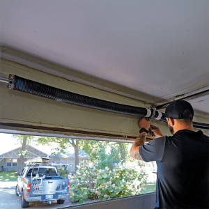Discount Garage Door technician replacing torsion spring on residential garage door in Tulsa Oklahoma
